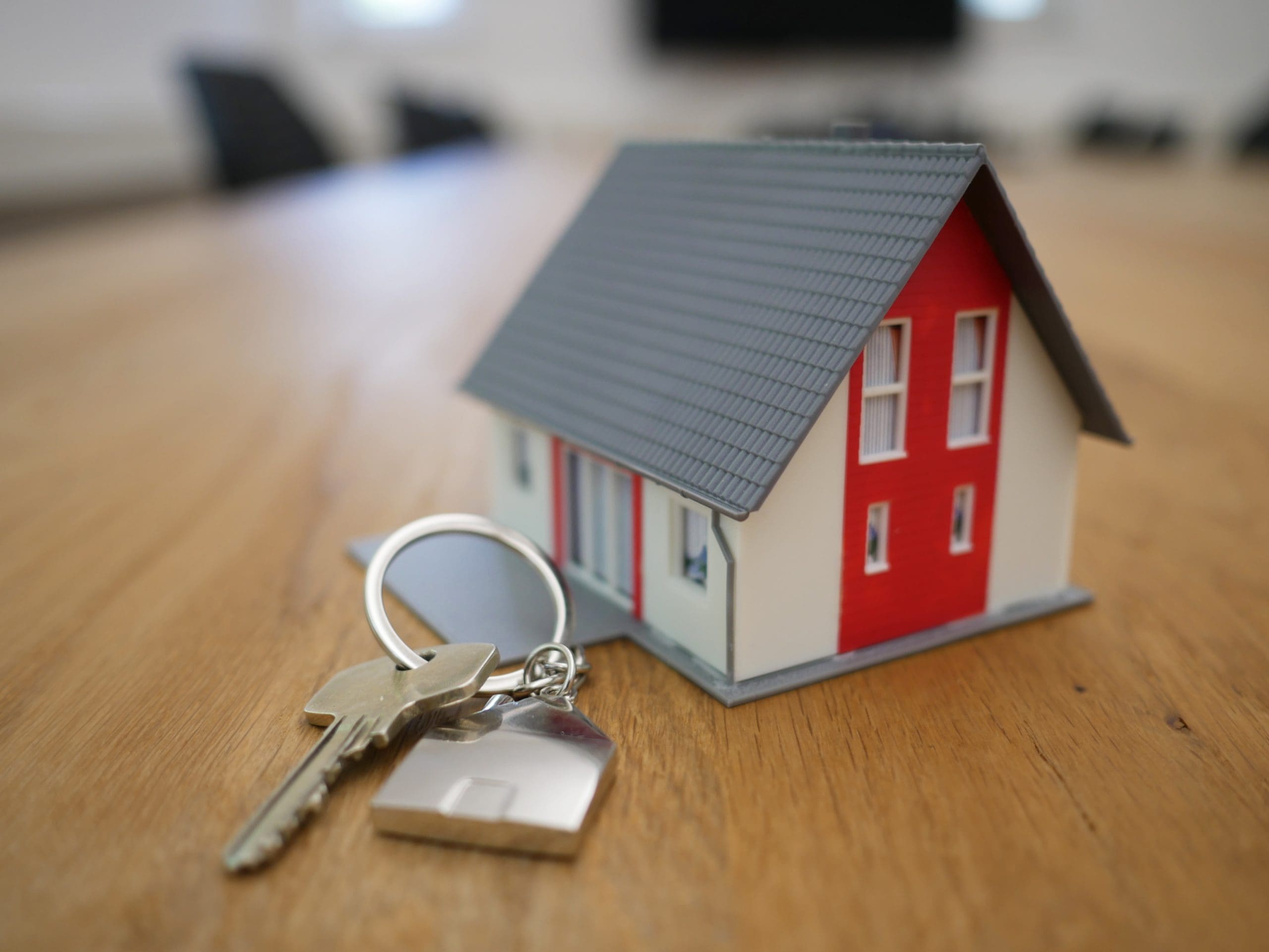 Miniature house with house keys on a table